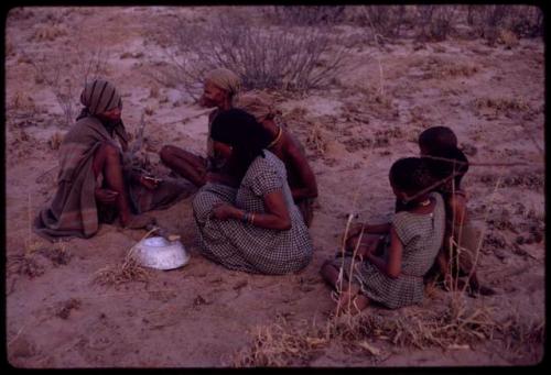 Women playing dandiri, including N/kxabe (daughter of /Oβa), Tomku, Dadum, and ǂKxoba, with a group of children sitting behind them