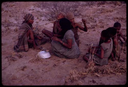 Women playing dandiri, including N/kxabe (daughter of /Oβa), Tomku singing, Dadum, and ǂKxoba, with a group of children sitting behind them