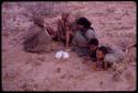 Women playing dandiri, including N/kxabe (daughter of /Oβa), Tomku, Dadum, and ǂKxoba striking the string with a stick