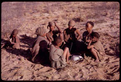 Women playing dandiri, including N/kxabe (daughter of /Oβa), Tomku, Dadum, and ǂKxoba, with two children sitting with them