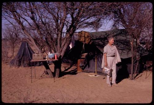 Lorna Marshall standing in front of a tent with a table next to it in the expedition camp