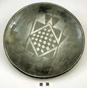 Black pottery plate with decoration.