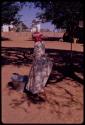 Woman standing next to a metal tub, view from behind