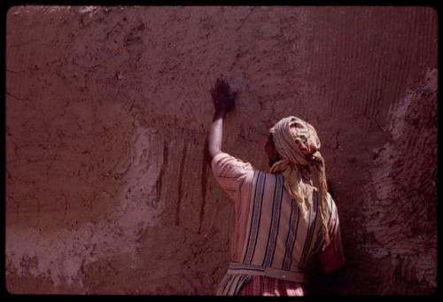 Woman plastering the exterior wall of a new house with mud and dung, in the compound of Boy Moapane, brother of the Kgalagari chief