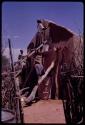 Woman plastering the exterior wall of a new house with mud and dung, in the compound of Boy Moapane, brother of the Kgalagari chief