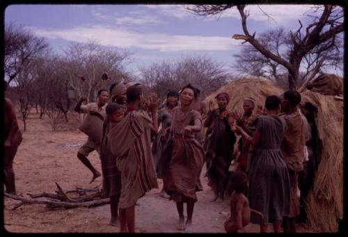 People performing the Eland Dance, with !Ani dancing in the middle of a circle of women clapping