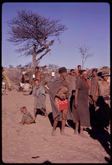 /Oβa and N//aba performing a social dance, with a group of people in the background