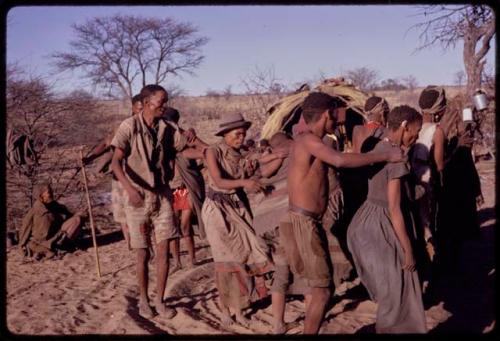 Group of people performing a social dance, including N/aoku, /'O /hei, and Dadum