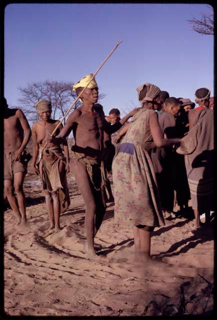 Tomku and /Xoxa performing a social dance, with other people behind them