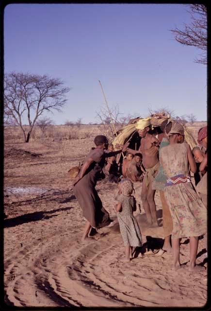 /Xoxa and N//aba performing a social dance together, with a little girl watching them