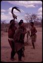 !Kxam dancing with an unidentified woman in a social dance, holding a wildebeest tail over her head
