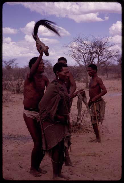 !Kxam dancing with an unidentified woman in a social dance, holding a wildebeest tail over her head