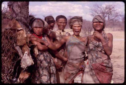 Group of women standing next to a tree, including (right to left) N/kxabe, Dadum, "Old ≠Nisa," Sãõ?//e behind her, and N≠am N/o (daughter of /Gaishay)