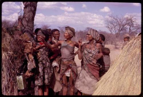 Group of women standing next to a tree, including (right to left) N/kxabe, Dadum, "Old ≠Nisa," Sãõ?//e behind her, and N≠am N/o (daughter of /Gaishay)