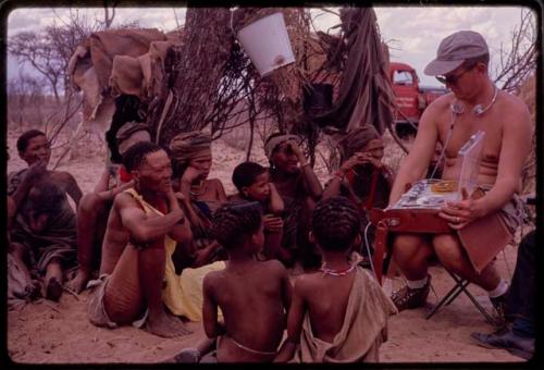 Group of people sitting, listening to a sound recording of a dance being played by Nicholas England