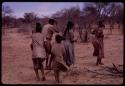 Group of people performing the Eland Dance, including !Ani (wife of Twi) on the right, ≠Kxoba wearing a checked dress and men wearing horns