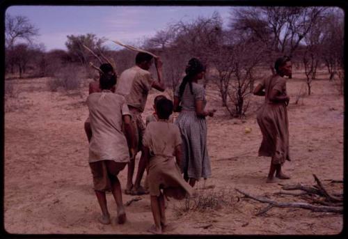 Group of people performing the Eland Dance, including !Ani (wife of Twi) on the right, ≠Kxoba wearing a checked dress and men wearing horns