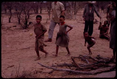 Children dancing in the Eland Dance, with Nicholas England and Wilhelm Camm walking behind them