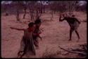 Children running near a man wearing horns at the Eland Dance