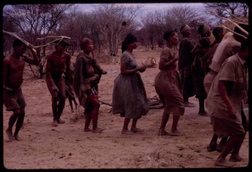 Group of people performing the Eland Dance, including !Ani, ≠Kxoba, /Khoa and !Kxam