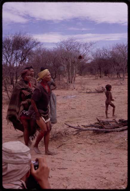 Four women performing the Eland Dance, including N//aba who has pulled up her dress to show her apron