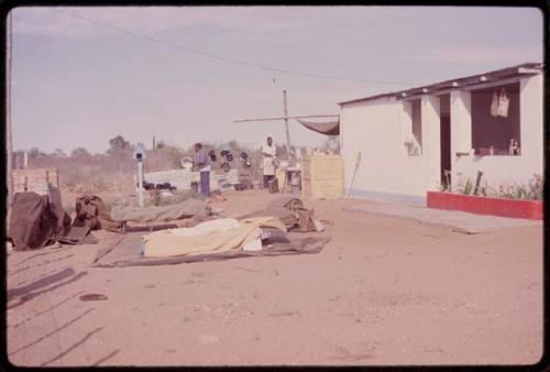 Two men cooking outside Craille's house, with their sleeping bags in the foreground