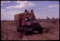 O.P.M. Prozesky and Wulf Haacke holding a gun and sitting on top of expedition Dodge on the way to Ghanzi District