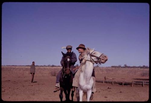 Johannes Brander (cattle foreman) riding on a black horse, with another man on a white horse