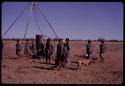 Group of people waiting for water to be poured at a borehole