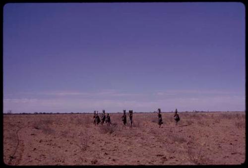 Group of women carrying buckets on their heads on their way back to werft