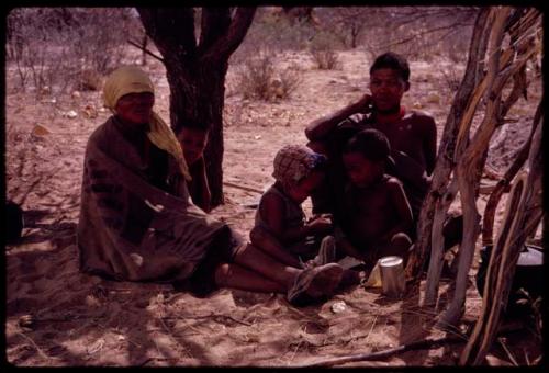 N//ana, her husband //Hao/ó (son of Sãó?//e), and their two children sitting near their skerm