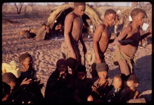 /Xoxa, /Gaishay, and Tama performing a curing dance around a group of women sitting in a circle