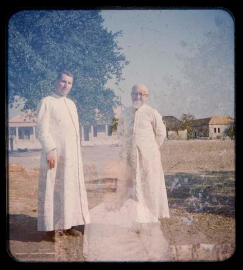 Father Mittlebarger (right) of Omupanda (mission station of the Rhenish Missionary Society in Oukwanyama in southern Angola) standing with another man (double exposure)