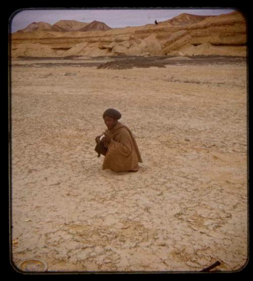 Guide man squatting at the Curoca Valley