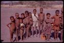 Group of children; Norna, in the plaid dress; to her left in red and white striped dress is //Kushay, wife of Tsamgao; ǂToma's son; daughter of /Qui and /Gasa; behind Norna is /Qui, son of Gau and Khan//a; boy in white suit is ǂToma's son, /Gaishay; and other children