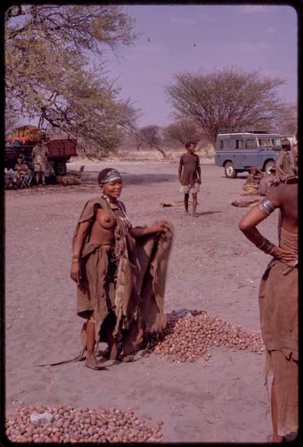 Woman standing beside her pile of mangetti nuts