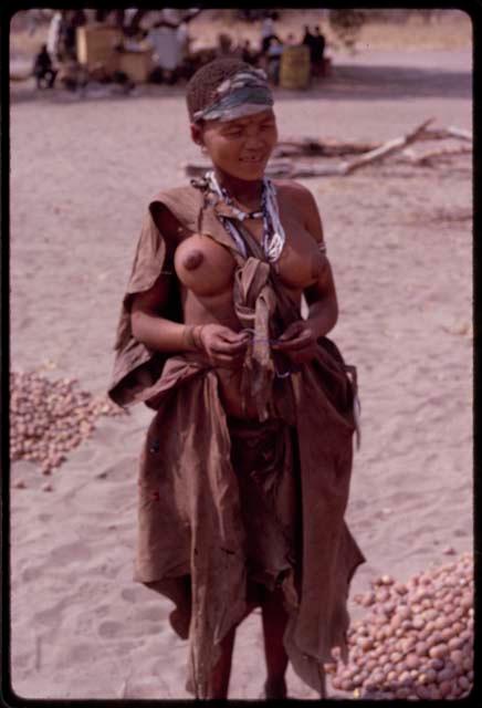 Woman standing beside her pile of mangetti nuts