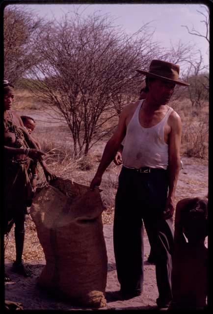 Wilhelm Camm helping to fill a sack with mangetti nuts