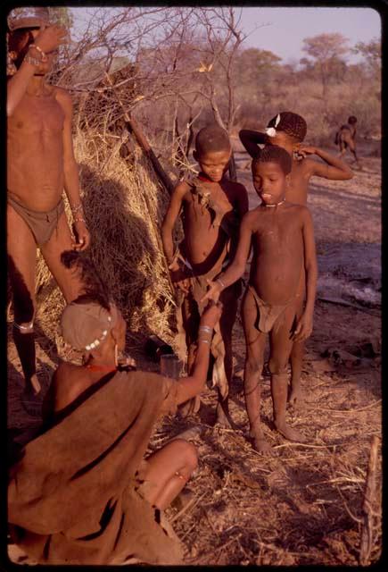 Women handing food to a group of children