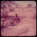 Food, Pounding: !Ungka pounding something in her mortar, with Sa≠gai sitting next to her