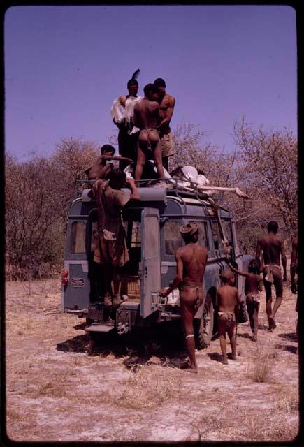 Men on top of expedition Land Rover to carry dead ostrich down