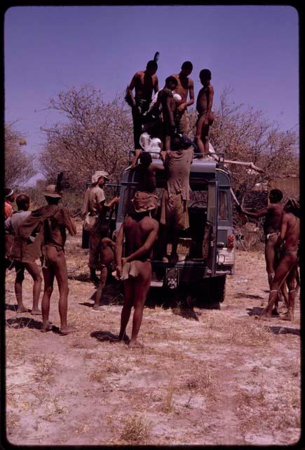 Men on top of expedition Land Rover to carry dead ostrich down