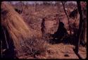 Women and children sitting in a patch of shade