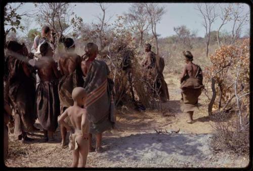 Women doing the Eland Dance, Nicholas England recording in the background, seen from behind