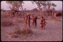 Children playing at a curing dance, girls clapping and singing and the boys dancing like the men