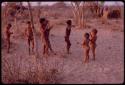 Children playing at a curing dance, girls clapping and singing and the boys dancing like the men