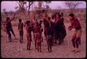 People gathering for a curing dance, ǂToma circling the women, and //Oshay dancing