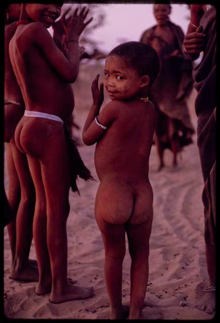 Children clapping and standing in a circle for a curing dance, close-up