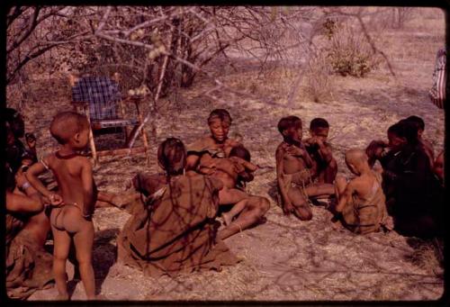 Women and children sitting at expedition camp