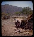 Cavale and Boalemuhung's wife sitting in front of a hut